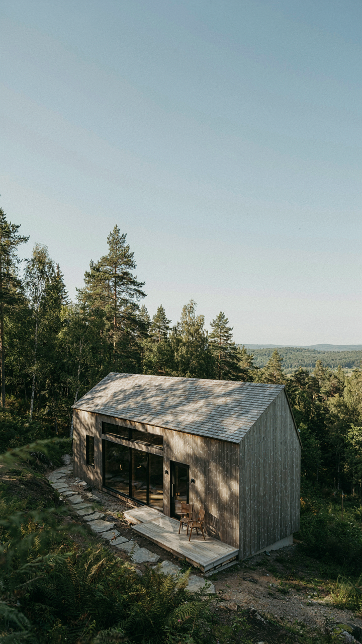 A modern guest cabin with a shed-style roof, weathered cedar, blending into nature.