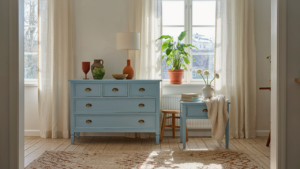 A bright swedish cottage interior with painted blue furniture and sunlight streaming in.