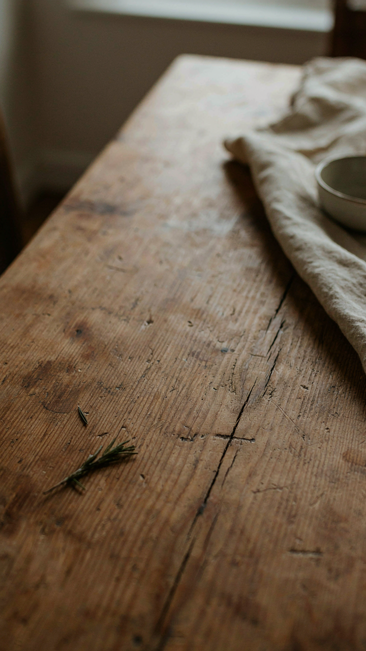 Close-up of a well-worn solid oak farmhouse table with natural patina.