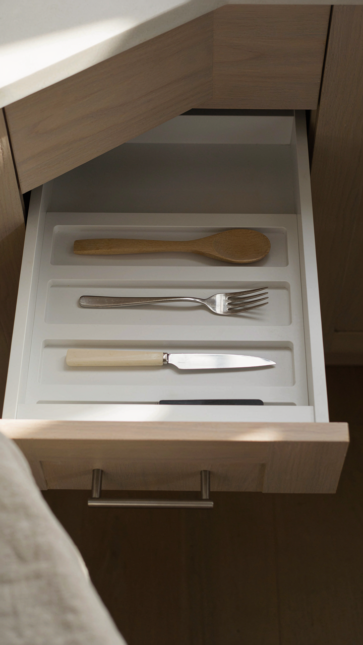 A perfectly organized kitchen drawer with only essential utensils, clear of clutter.