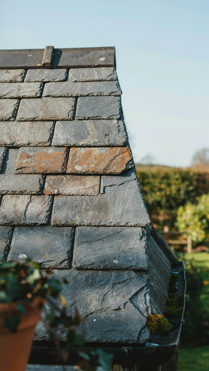 A unique garden shed roof made from reclaimed, weathered slate tiles.