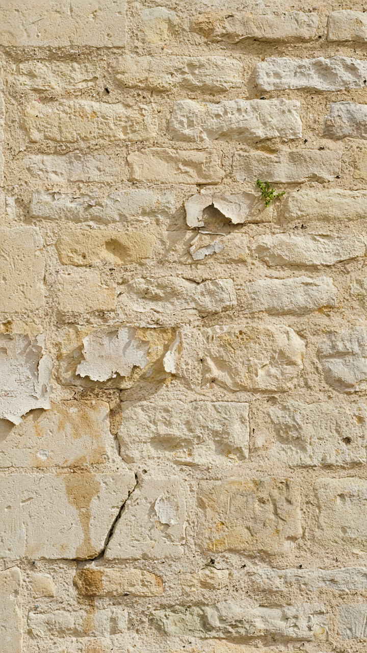A close up of a lime-washed stone wall on an old European cottage.
