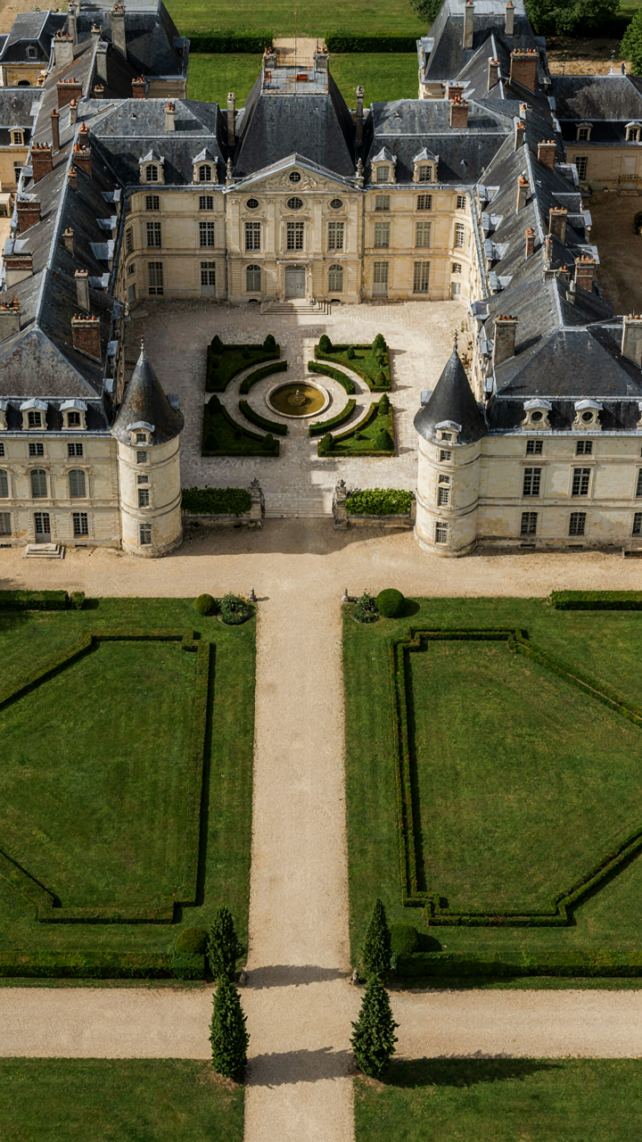 A symmetrical French chateau exterior with twin turrets forms a strong visual axis.