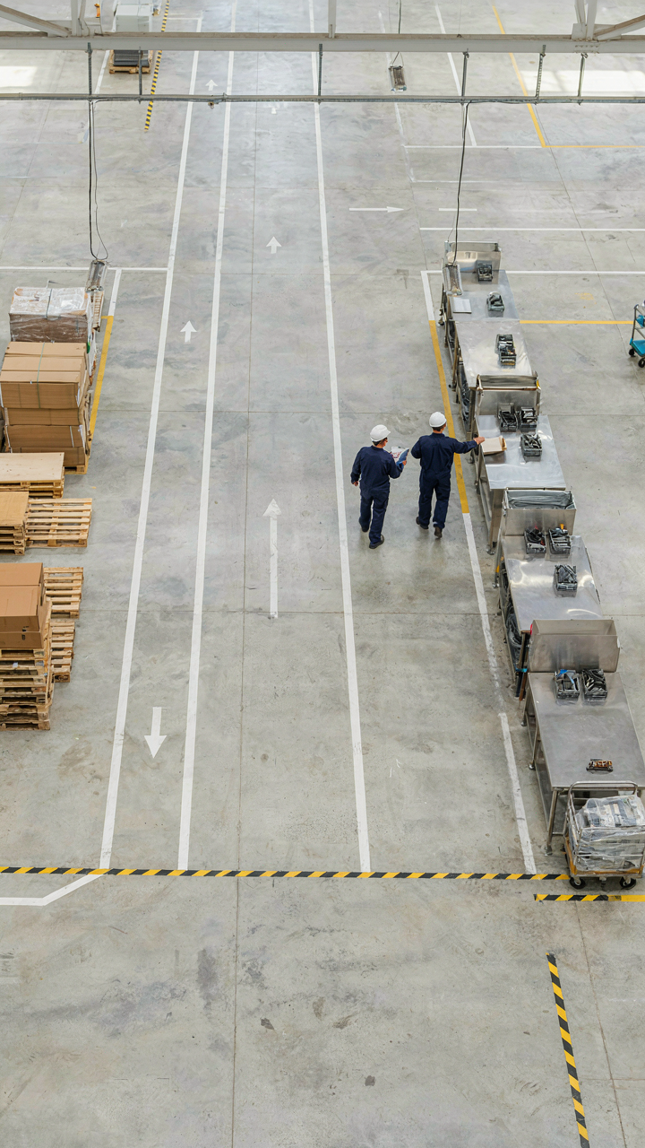 An overhead view of a factory floor with painted lines showing movement paths.