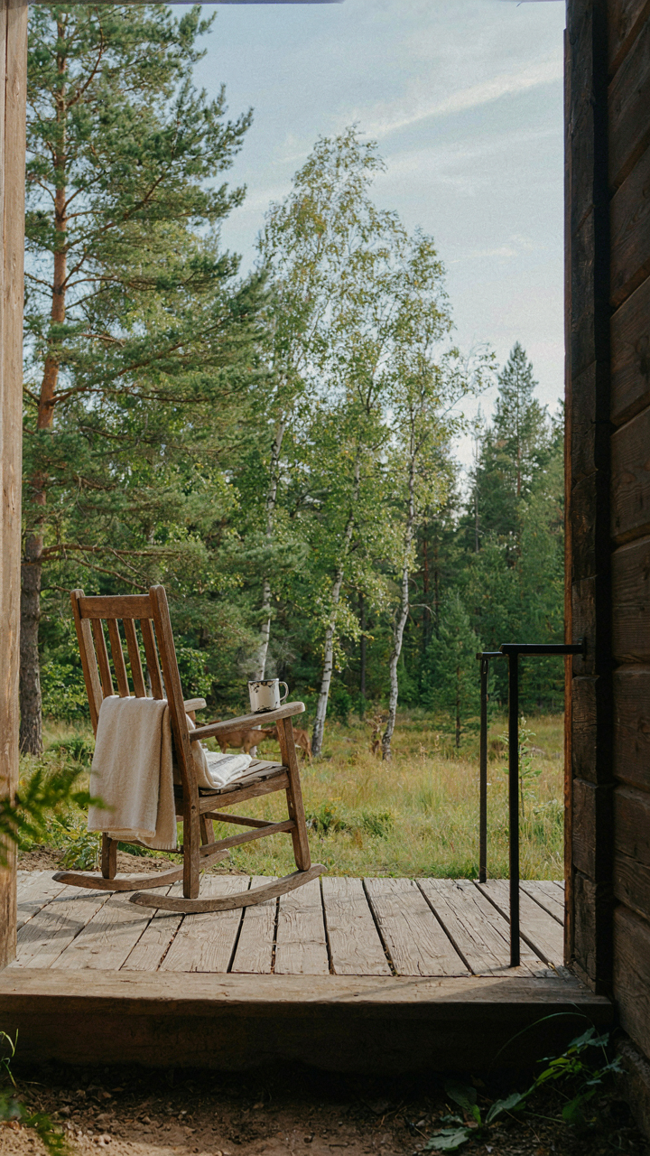 A tiny cabin porch offers a clear view of trees and open sky.