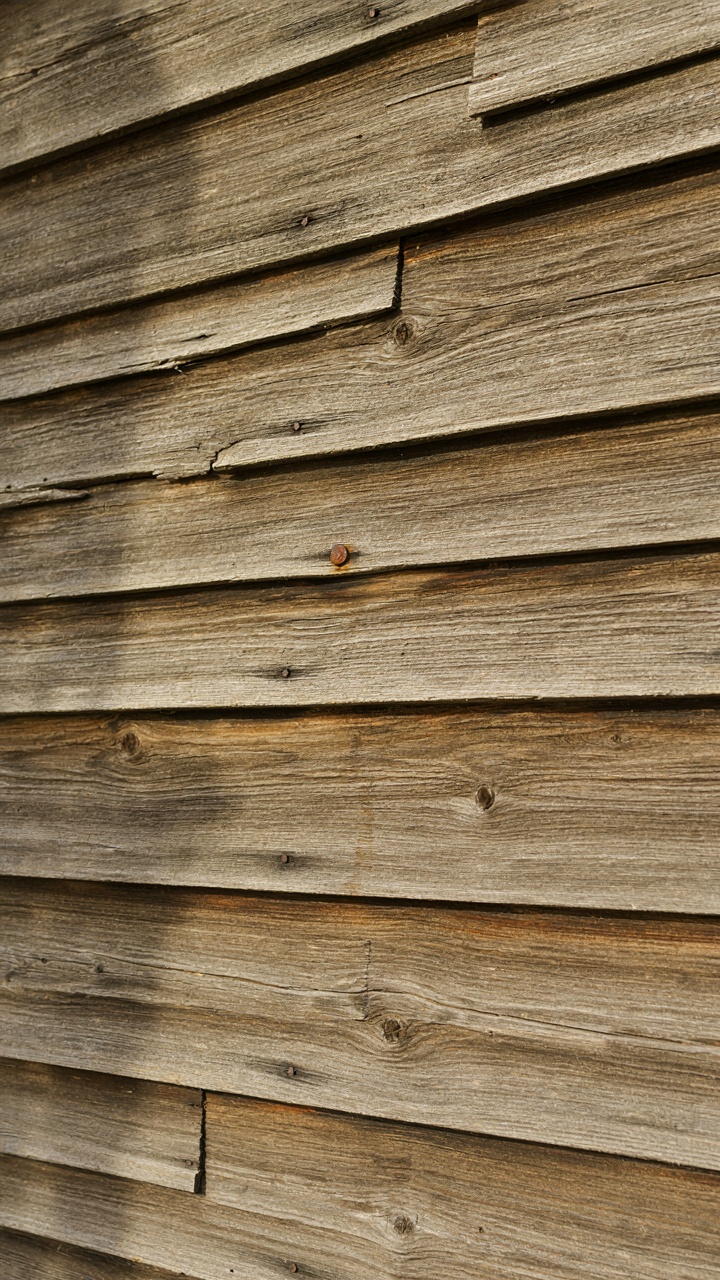 Close-up of overlapping cedar clapboard siding on a farmhouse, showing water shedding.
