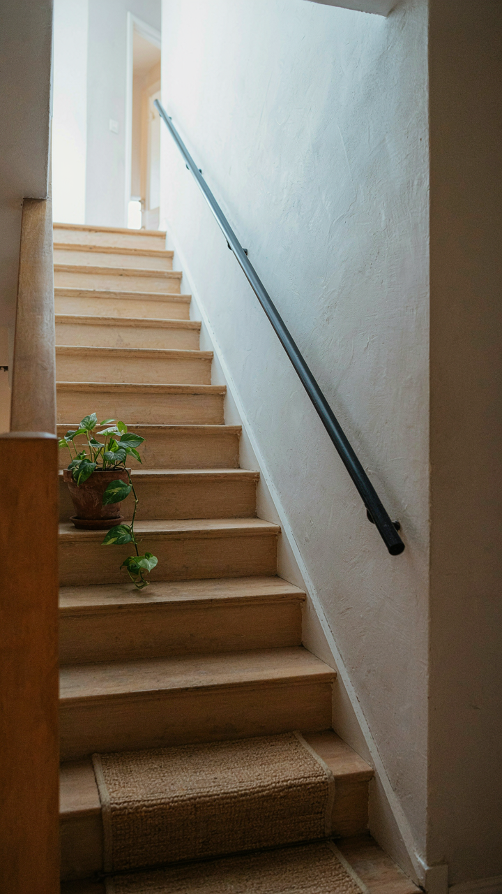 A small, tightly fitted wooden cottage staircase in a compact space.