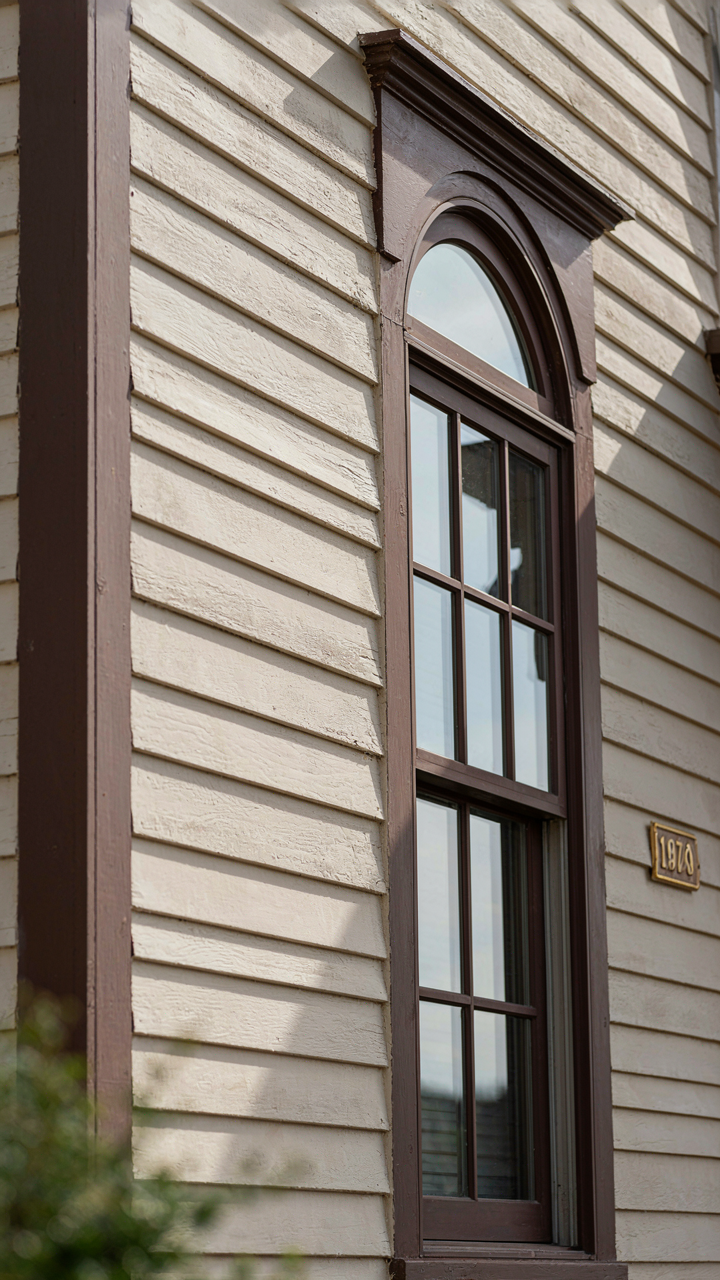 Dark trim creates a strong contrast against light siding on a craftsman home.