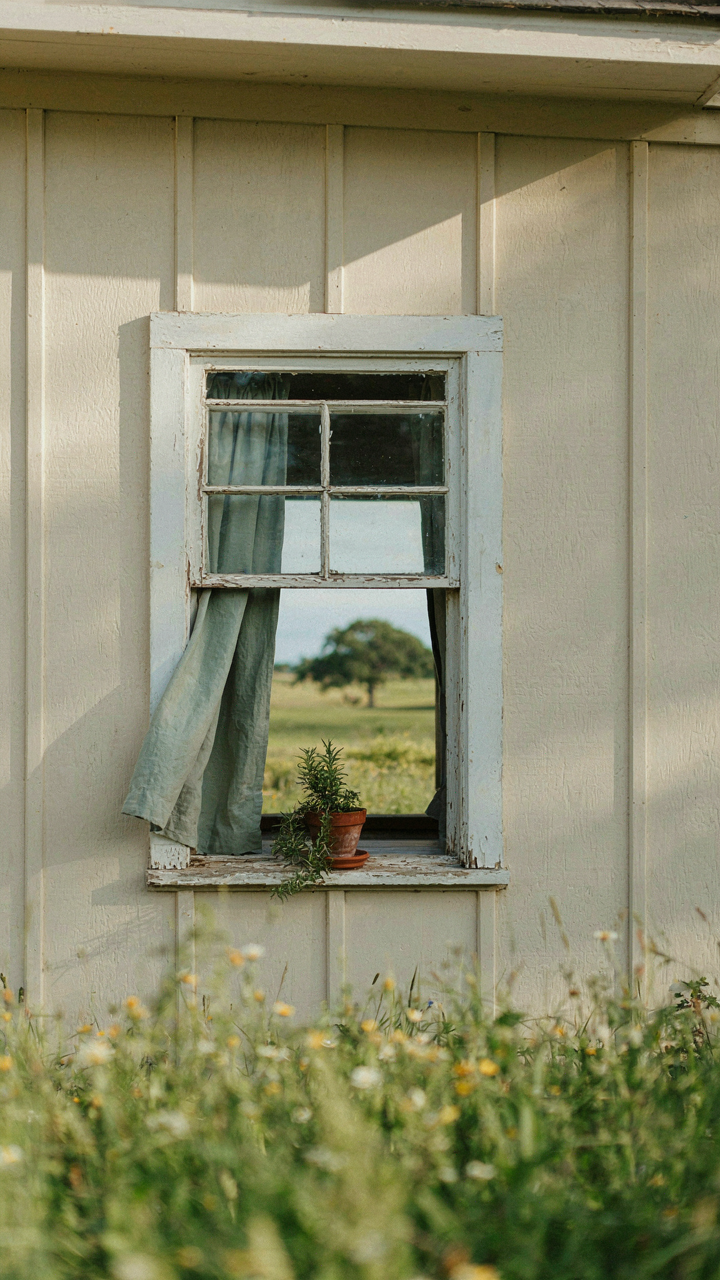 An open farmhouse window with a deep sill and a wide roof overhang.