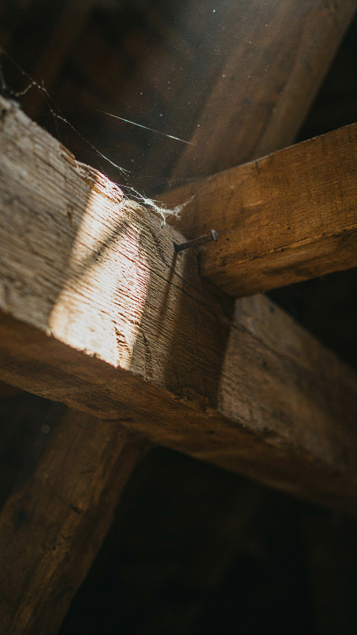 A close-up of a sturdy exposed timber beam with visible, hand-cut joinery.