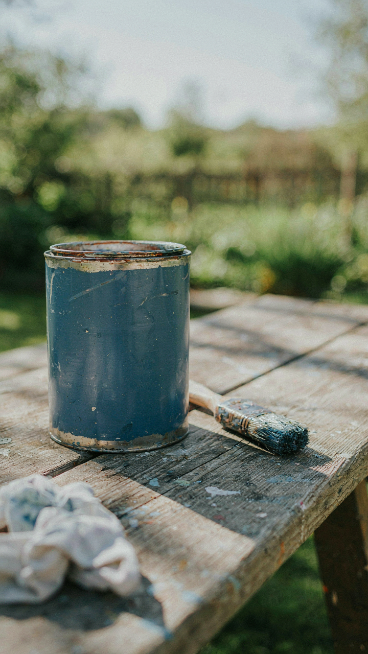 A durable paint can on an outdoor workbench.