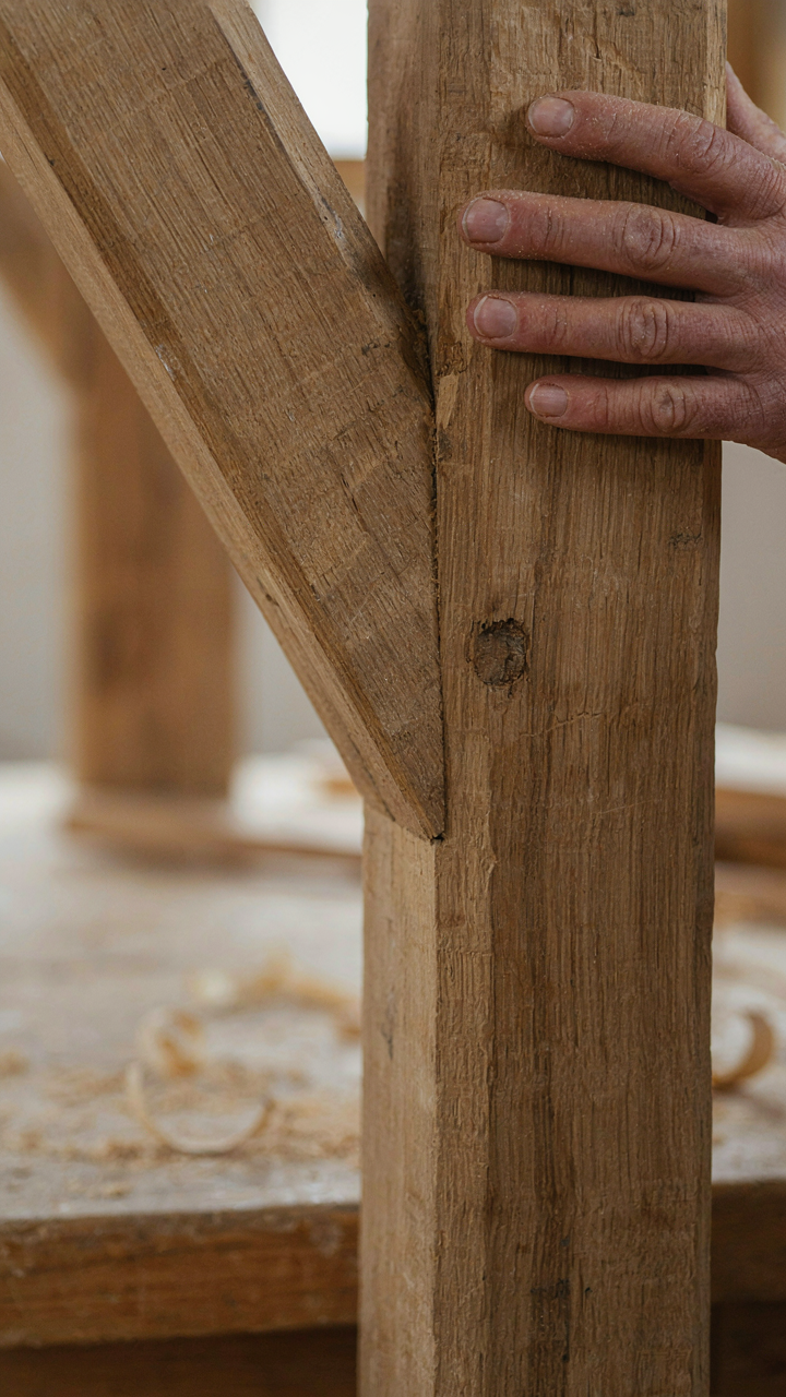 A close-up of a hand-hewn timber frame joint without metal parts.
