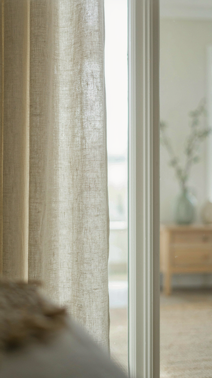 A close-up of a linen curtain showing its natural texture and diffused light.