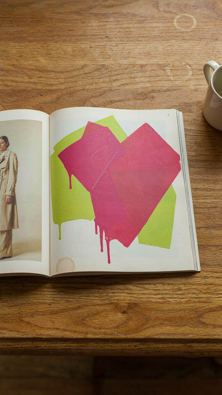 An old, faded fashion magazine open to an outdated paint advertisement.
