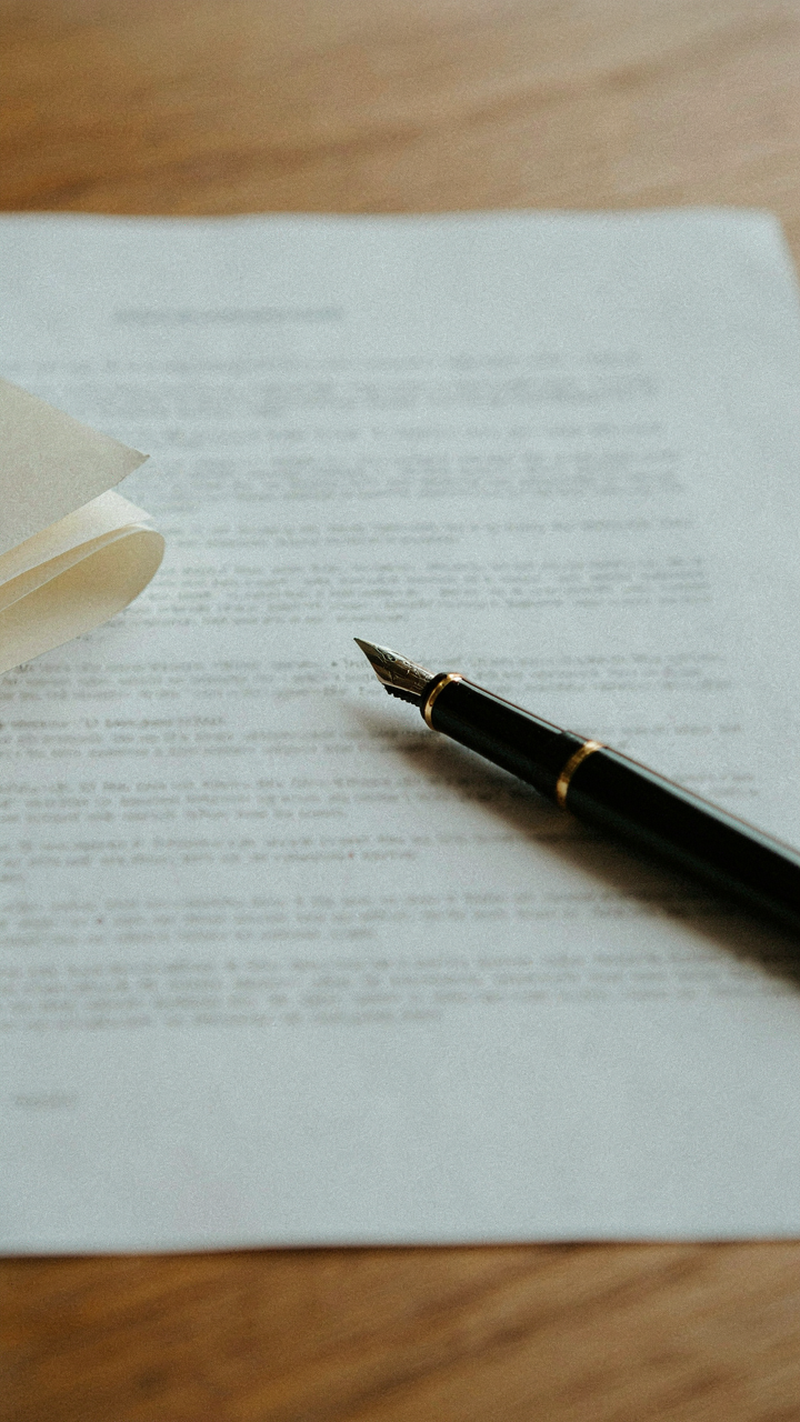 A legal document with a pen resting on it, symbolizing a formal agreement.
