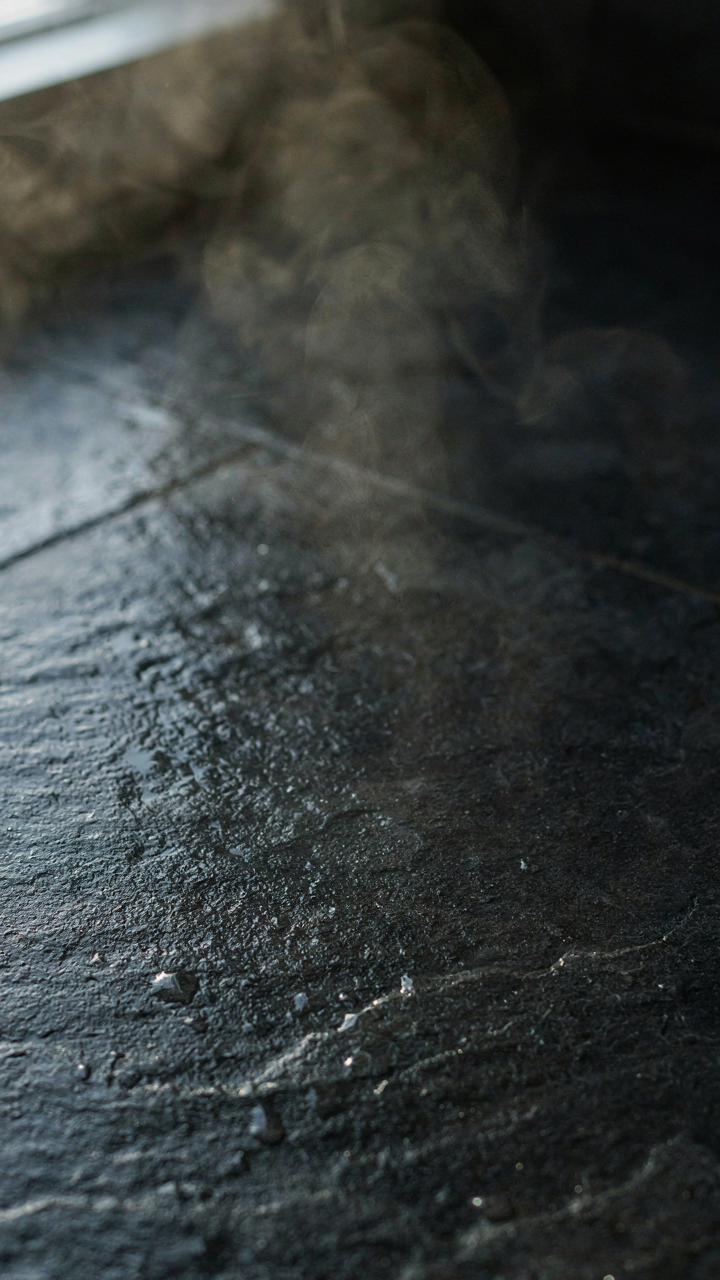 Dark slate bathroom floor absorbs heat from a steamy shower.