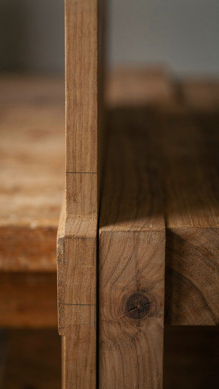 A close-up of solid wood joinery, showing natural grain and hand finish.