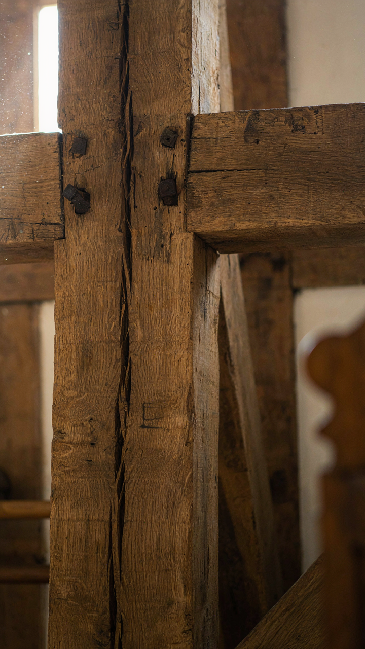 Close-up of old, weathered oak timbers, showing their natural texture.