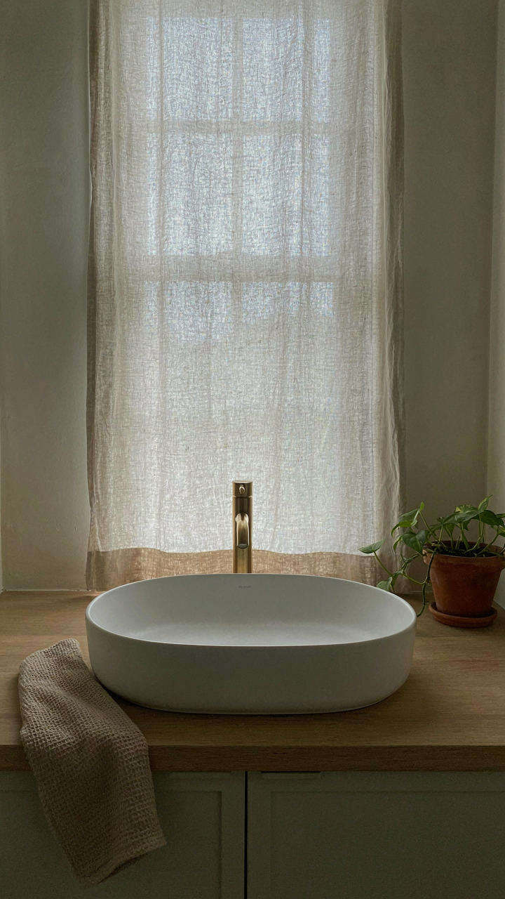 A modern rustic bathroom vanity has a 24-inch white basin.
