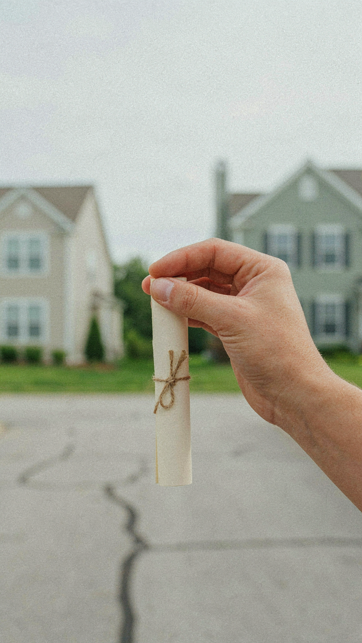 A hand holds a small, rolled-up written agreement, symbolizing boundaries.