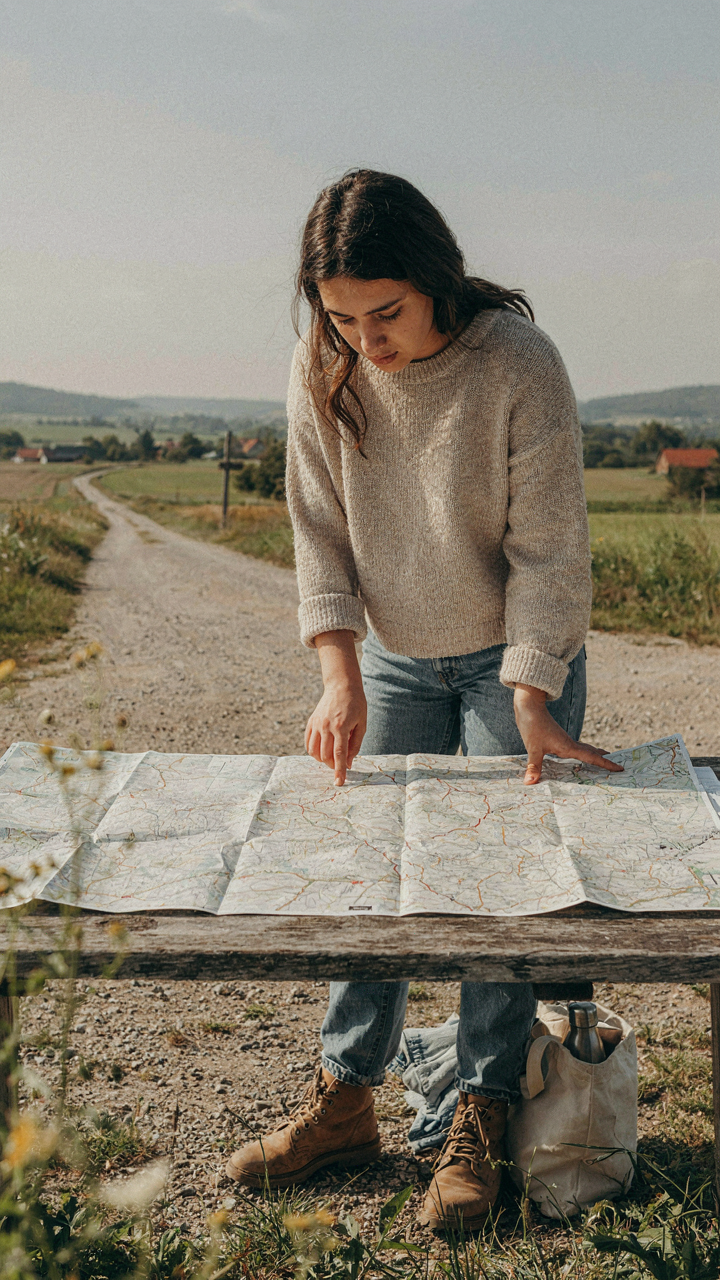A person stands at a crossroads, studying a detailed map to make a strategic decision.