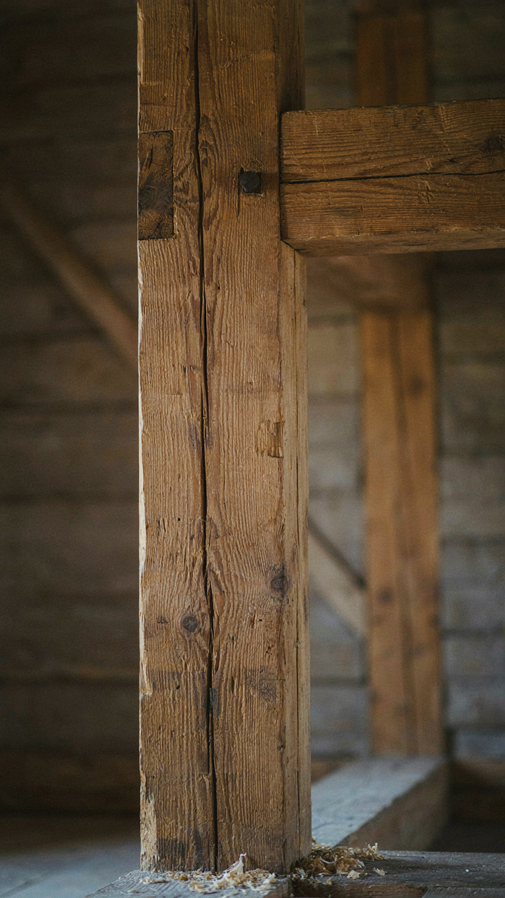 Close-up of a sturdy hand-hewn timber frame joint in an old building.