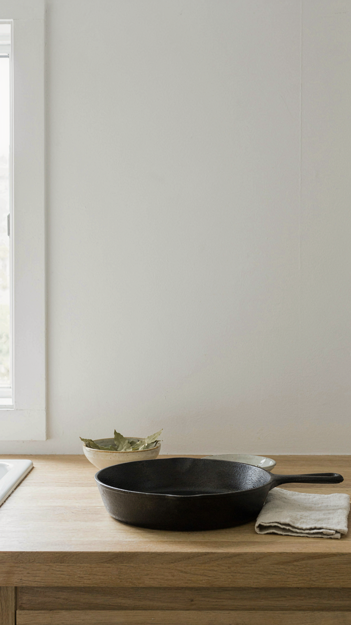 A cast iron skillet on a clean counter in a minimalist tiny cabin.