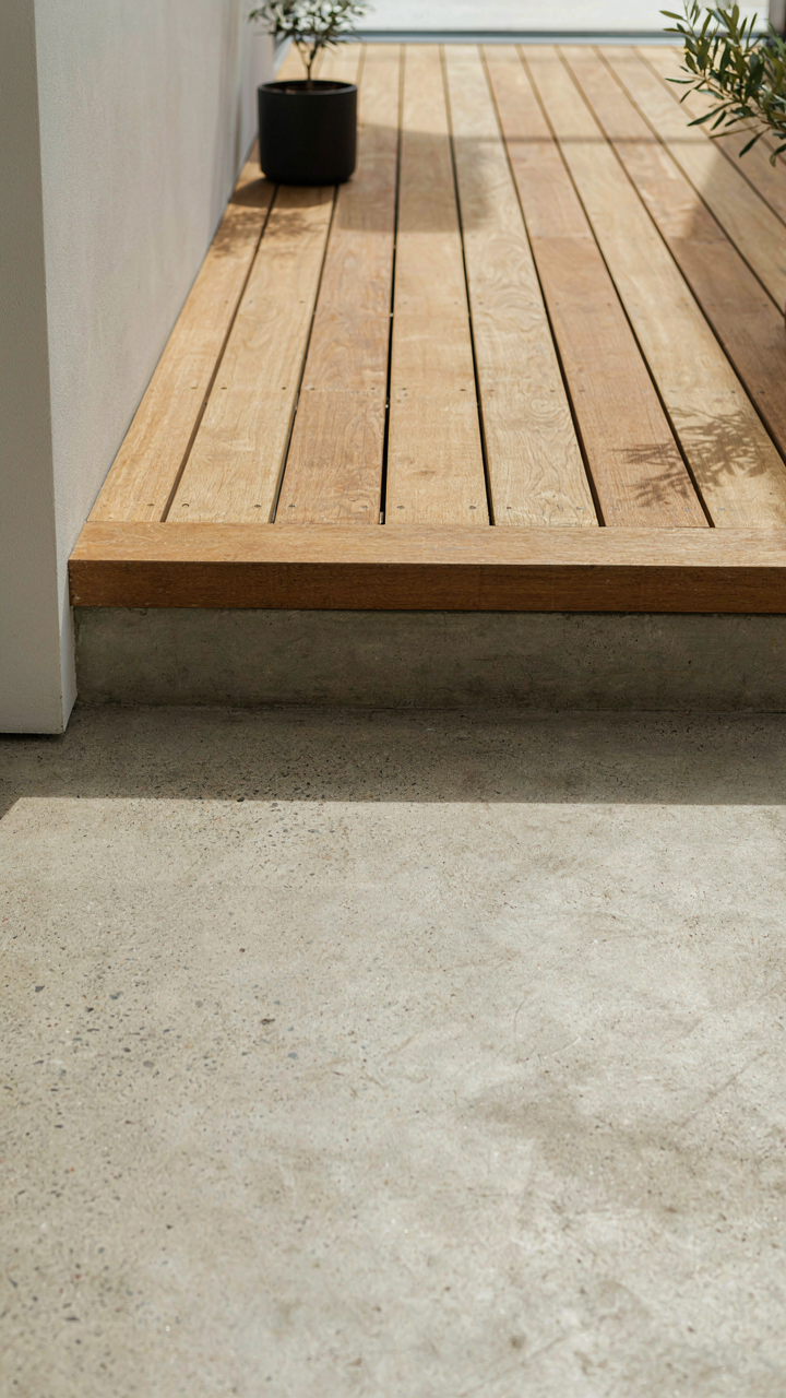A subtle step where an indoor concrete floor meets an outdoor timber deck.