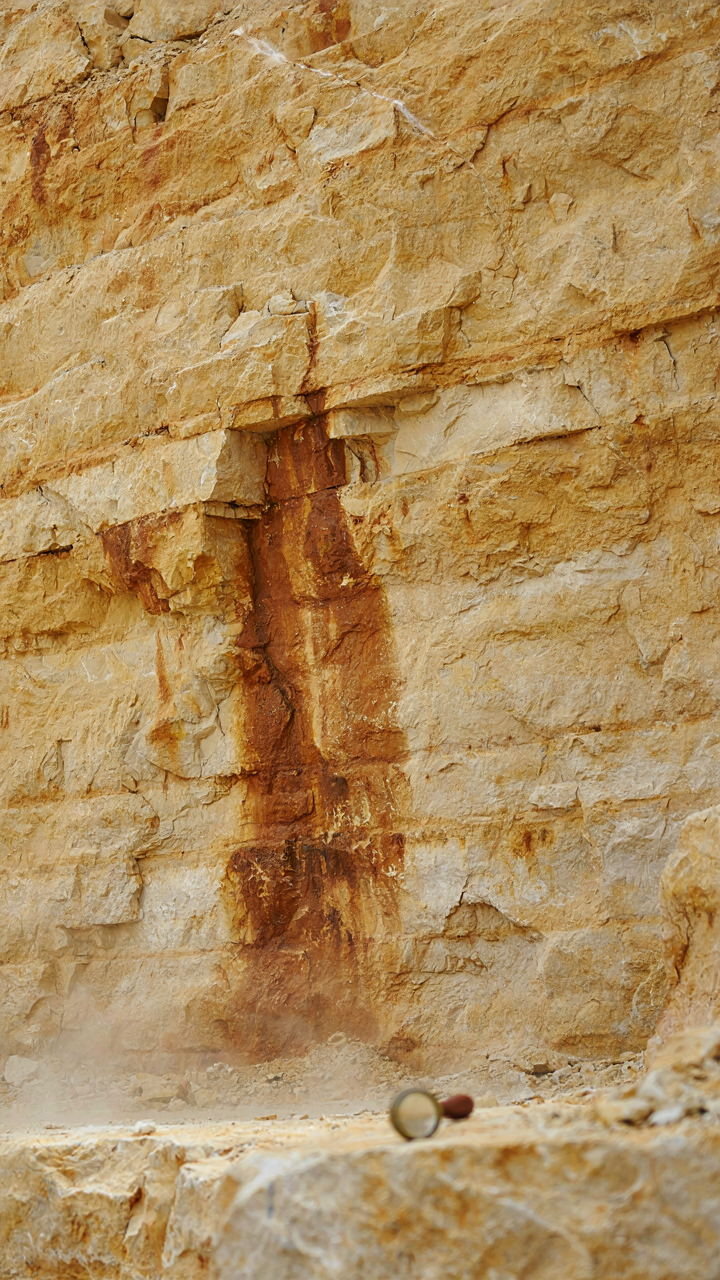 Close-up of ancient yellowish-golden limestone rock layers in a quarry.