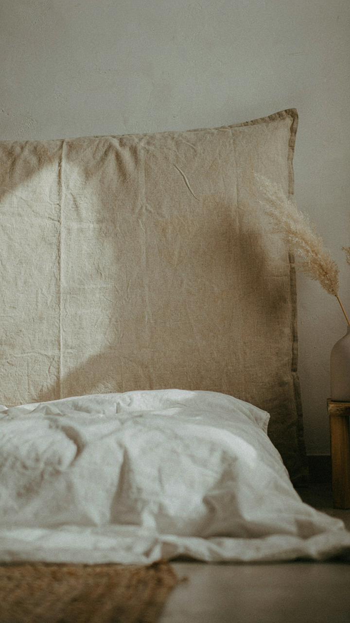 A linen headboard with uneven fading, showing authentic wear from sunlight exposure.