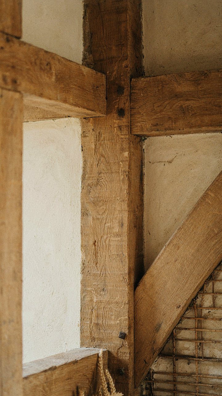 A large, hand-hewn oak timber beam as part of a structural wall.