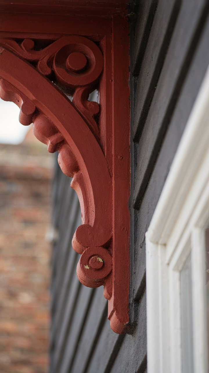 A terracotta accent on a charcoal Victorian house architectural detail.