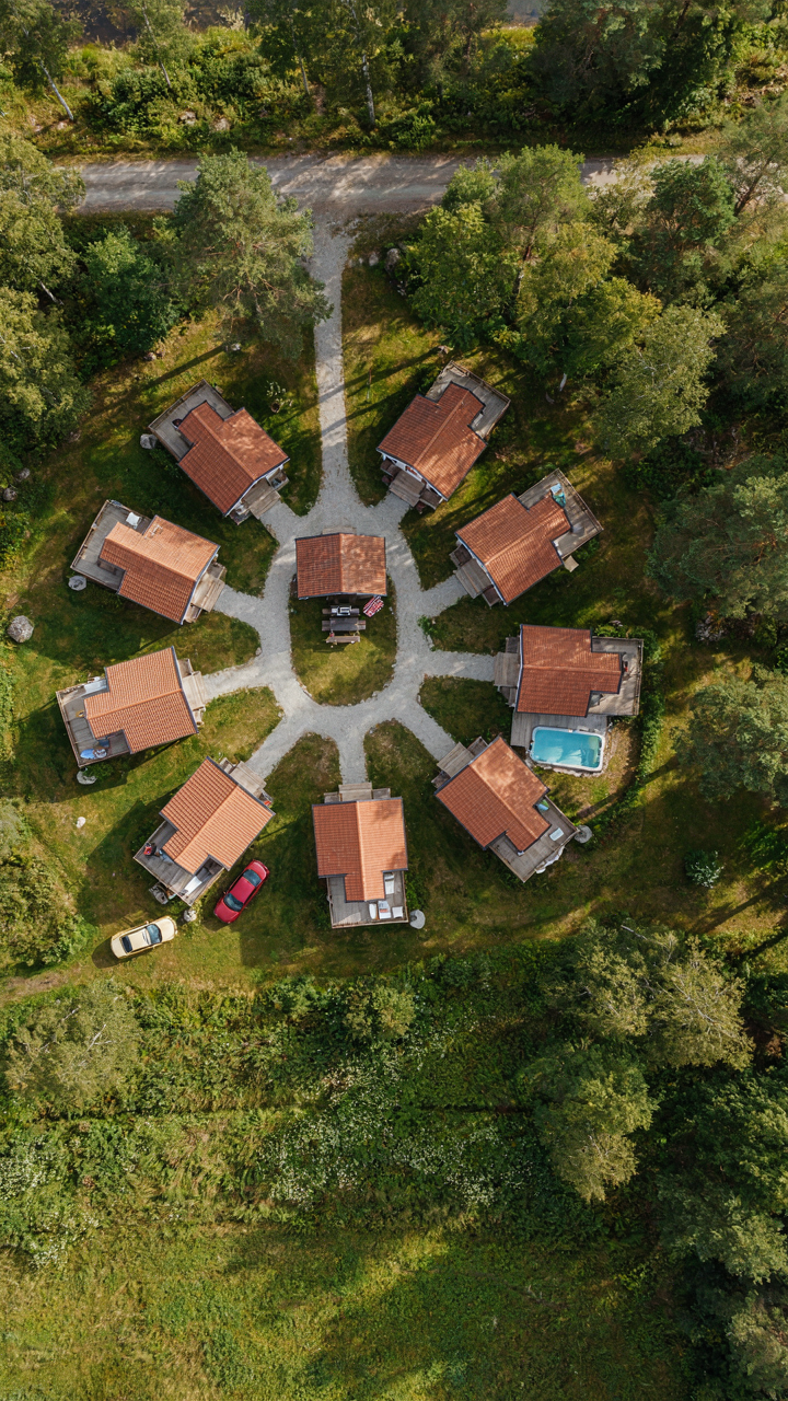 An aerial view of a small community of vacation cottages connected by paths to a pavilion.