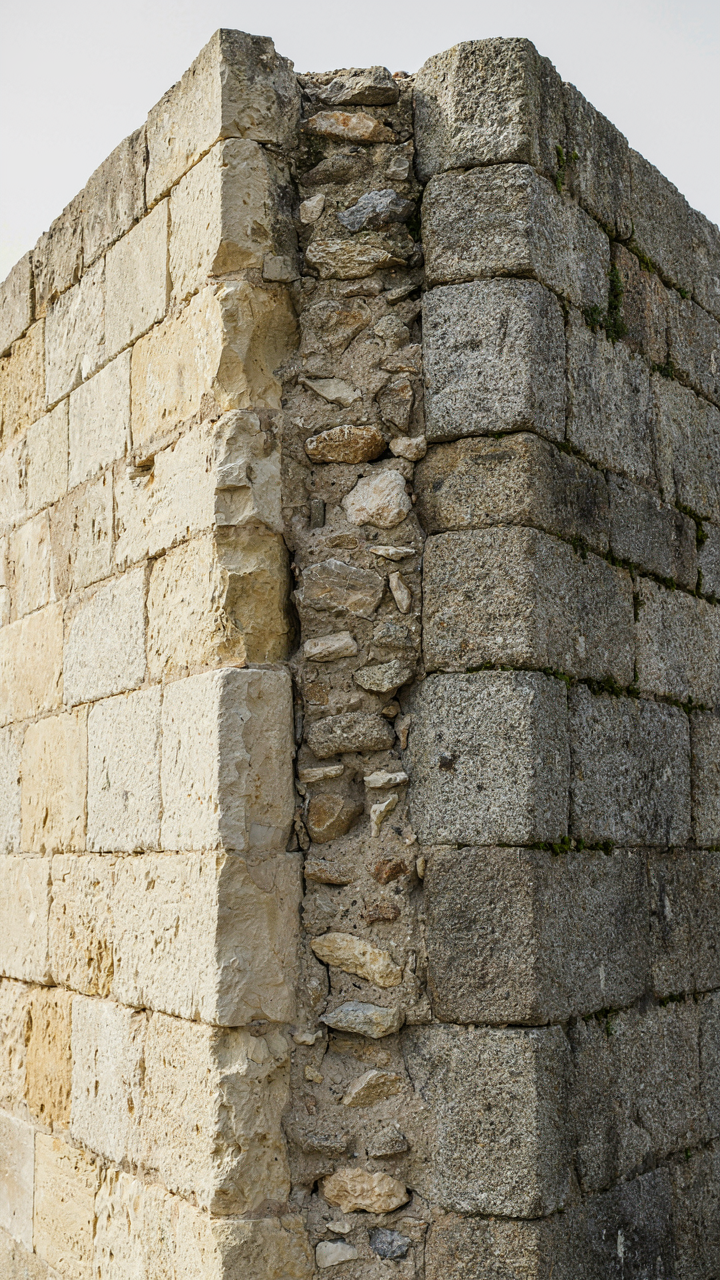 A cross-section view of a thick, double-leaf stone wall.