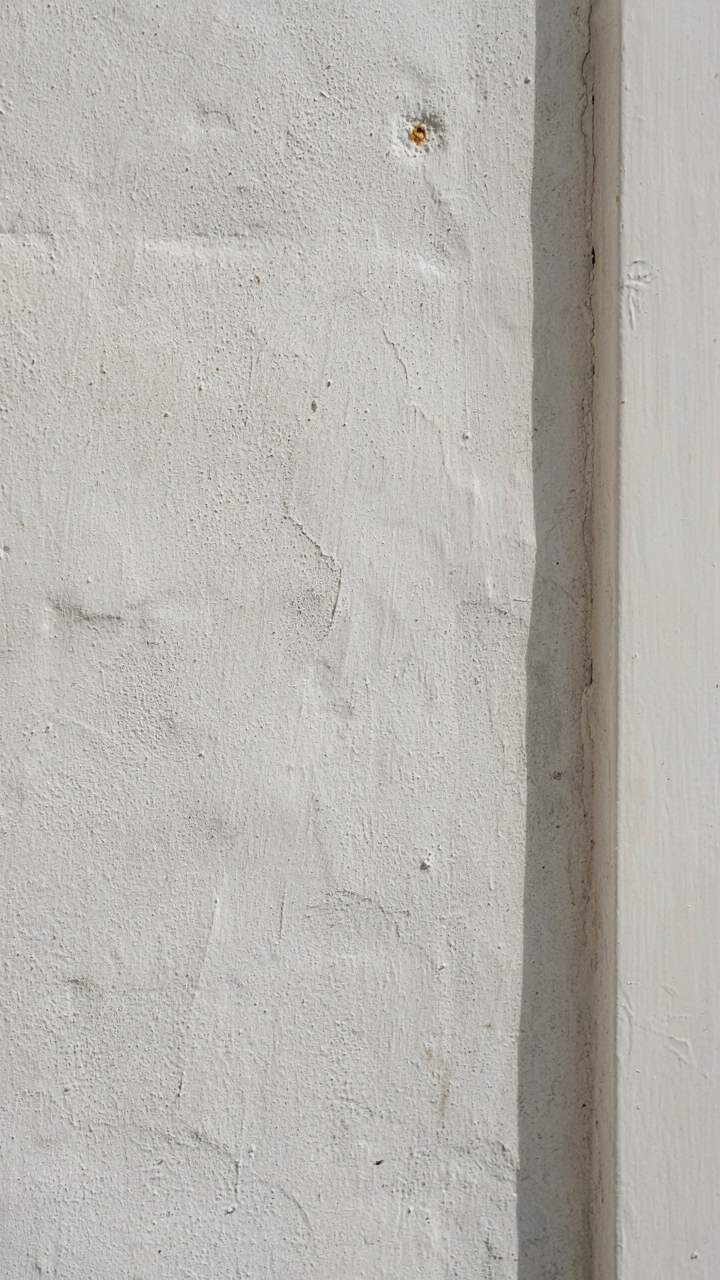Close-up of a white lime washed colonial farmhouse exterior wall.