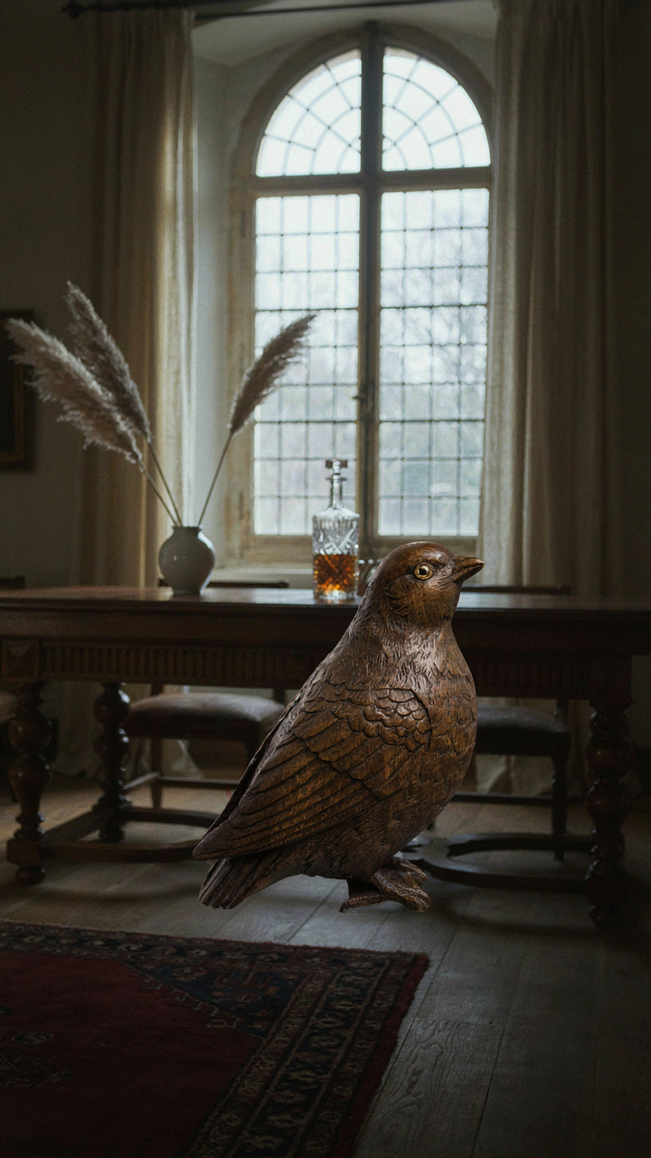 A single carved wooden bird figurine sits on a dark wood sideboard.