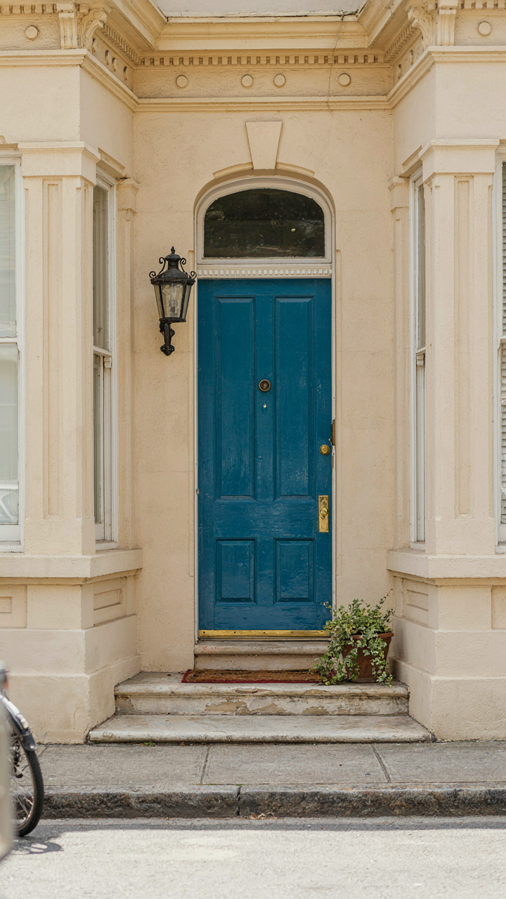 A bold teal blue front door on a neutral Victorian house.