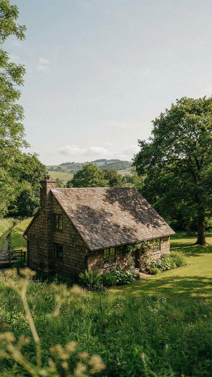 A cottage with deep roof overhangs blocking high summer sun and a swale diverting water.