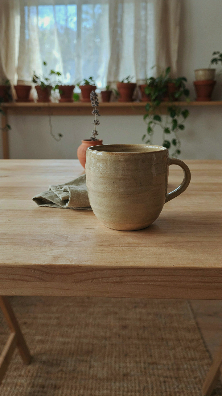 A custom ceramic mug placed on a clean desk in a she shed interior.